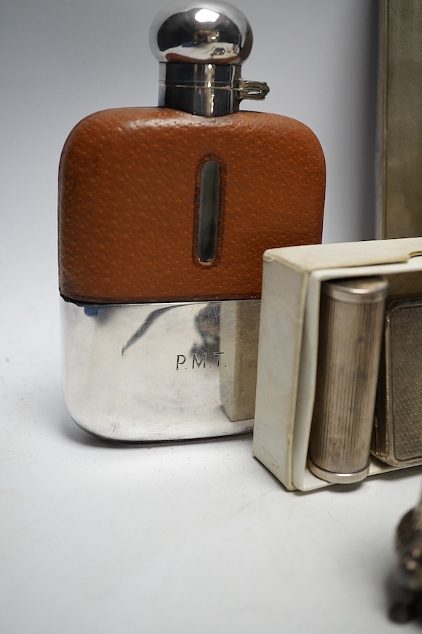 A collection of white metal and hallmarked silver to include three photo frames, a mounted glass flask, a compact, a lipstick holder, a cased pair of Victorian pepper pots, two pairs of Georgian sugar tongs and a mounted